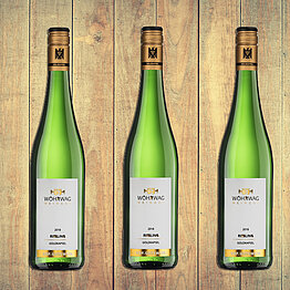 Drei Weinflaschen vom Weingut Wöhrwag Drei Weinflaschen nebeneinander auf hölzernem Hintergrund