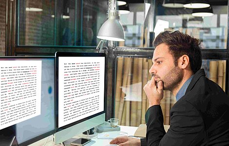 Stellenausschreibung Qualitätsmanager. Bild mit Mann vor dem Computer.